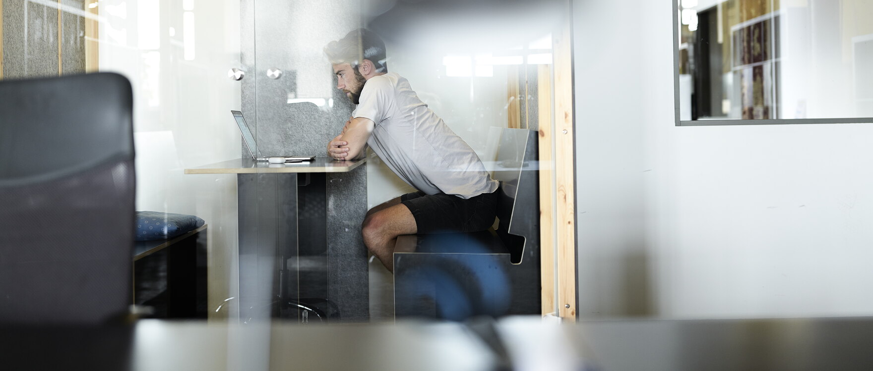 Mitarbeiter sitzt am Laptop in einem Büro.