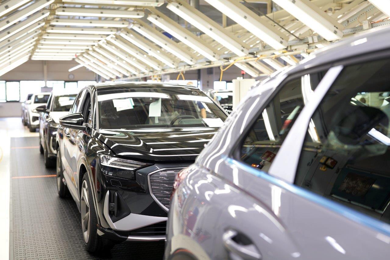 Mehrere Fahrzeuge stehen im Automobilwerk hintereinander.